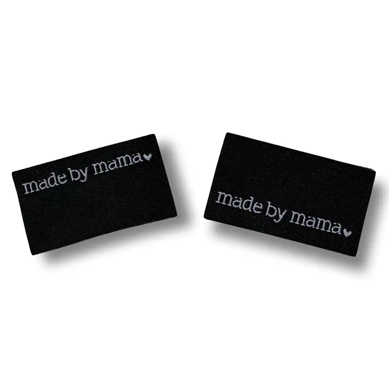 2 schwarze Weblabel mit der Aufschrift "made by mama"