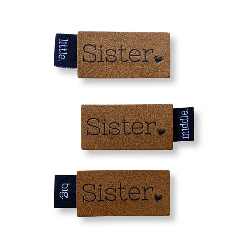 3 Lederlabels mit Aufschrift Sister seitlich ein Weblabel mit Aufschrift