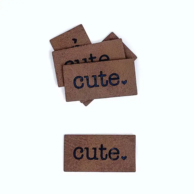 braune Lederlabels mit schwarzer Aufschrift "cute" und ein kleines Herz