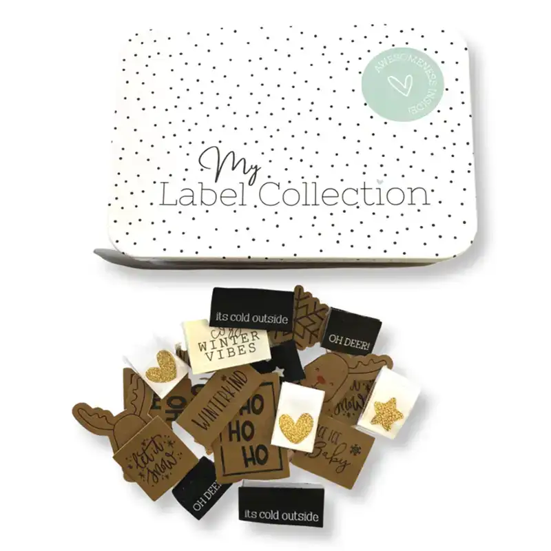 Metallbox zu Aufbewahrung von Labels mit weißem Deckel und schwarzen Punkten mit dem Schriftzug My Label Collection und eine Auswahl aus Web- und Lederlabels zum Thema Weihnachten und Winter